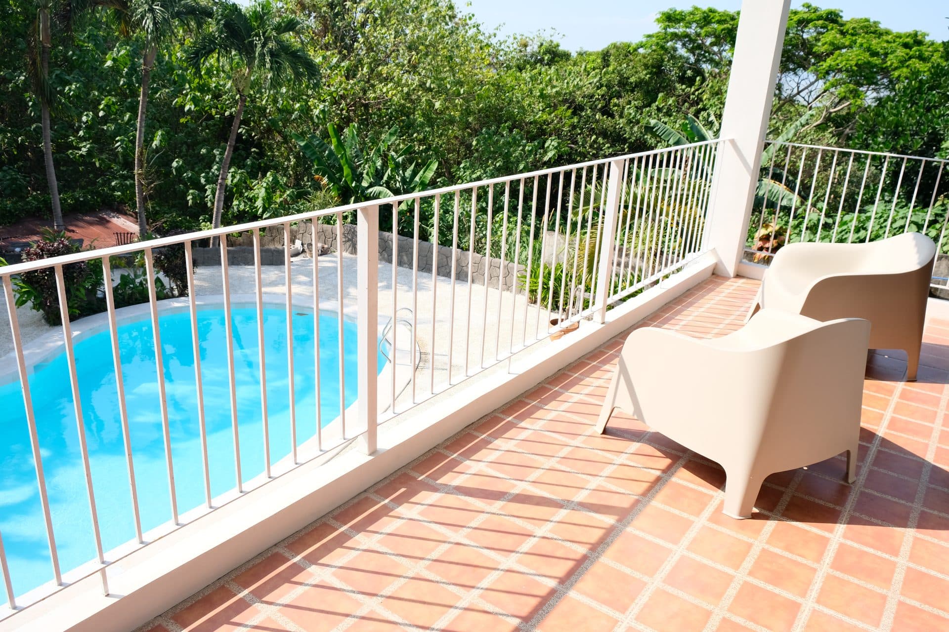 Balay sa Pansol upper balcony lounge area with pool view and lush tree canopy